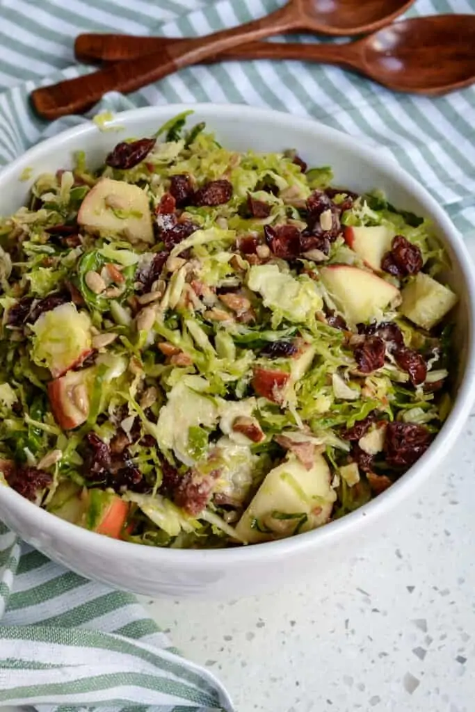 Beautiful Brussels Sprout Salad is full of crisp apples, sweet pecans, dried cranberries, smoked bacon, sunflower seeds, and fresh Parmesan, all drizzled with a delicious honey mustard vinaigrette. 