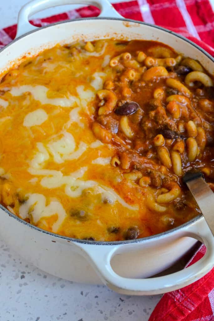 A Dutch Oven filled with chili mac, pasta, and cheese