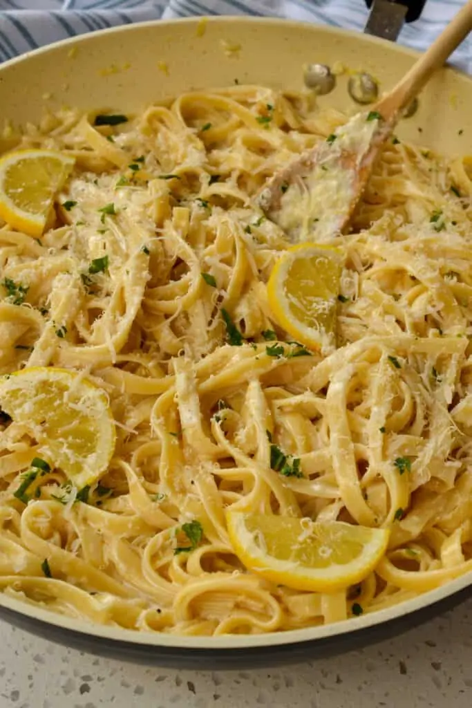 Lemon pasta garnished with lemon slices. chopped fresh parsley, and Parmesan Cheese. 
