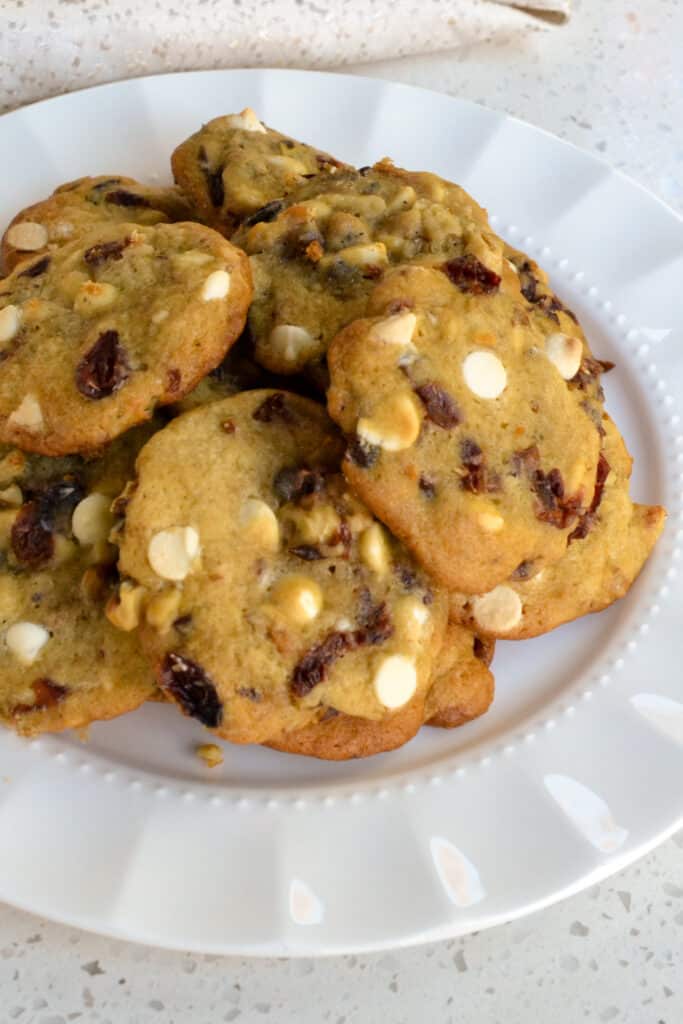 A plate full of cranberry and white chocolate chip cookies. 