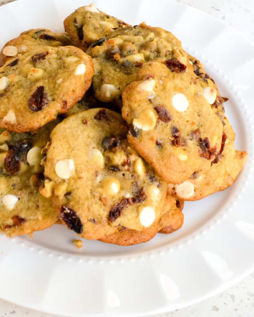 White chocolate cranberry cookies on a white serving plate.