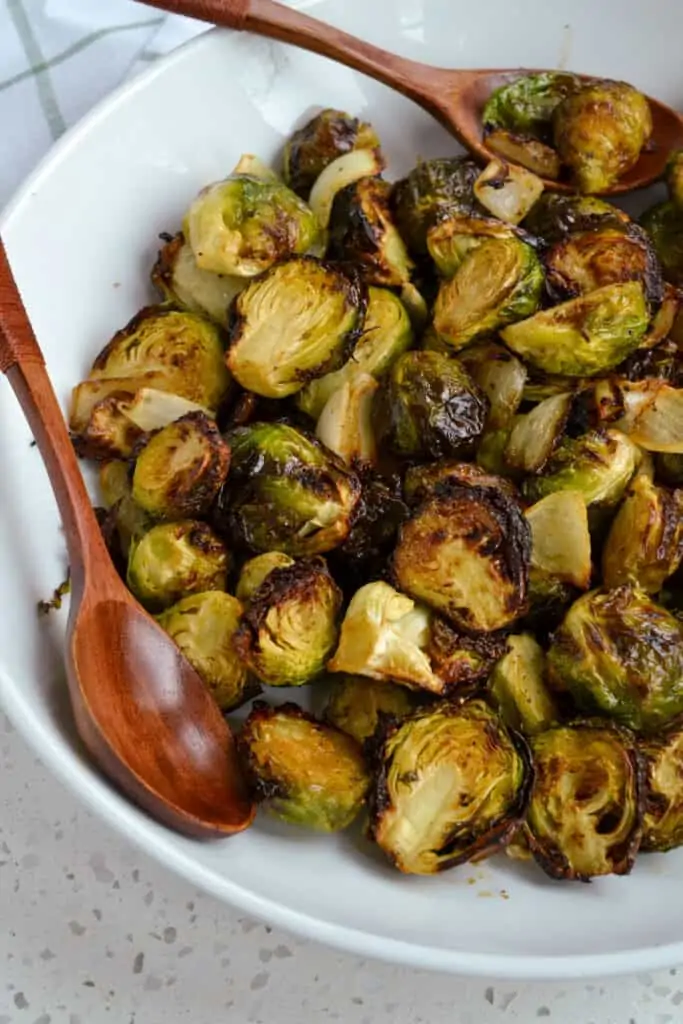 This Air Fryer Brussels Sprouts recipe is so delicious, quick, and easy. Fresh Brussels sprouts and onions are tossed with olive oil, maple syrup, garlic powder, onion powder, salt, and pepper