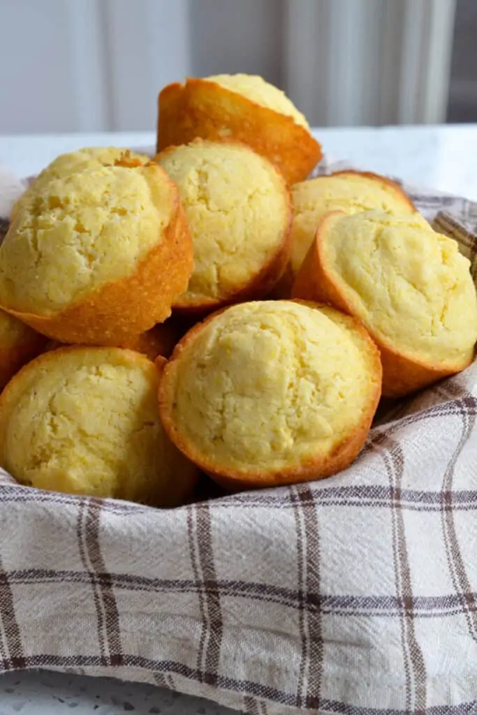 A basket full of fresh baked corn muffins.