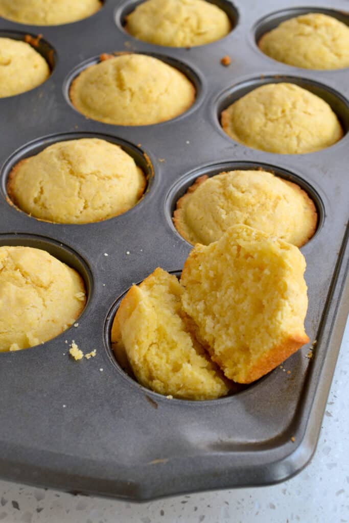A fresh baked split corn muffin with butter.