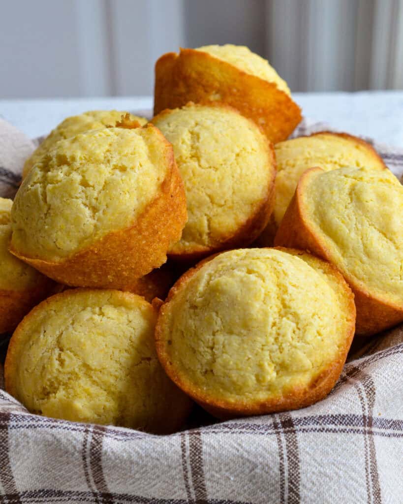 A basket full of fresh baked corn muffins.