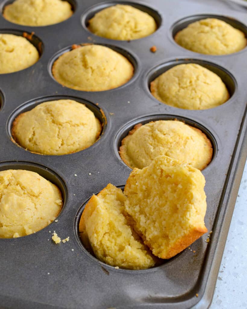 A fresh baked split corn muffin with butter.