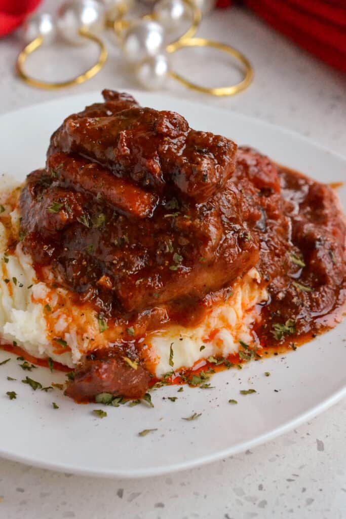 Beef Swiss Steak over mashed potatoes with carrots and onions. 