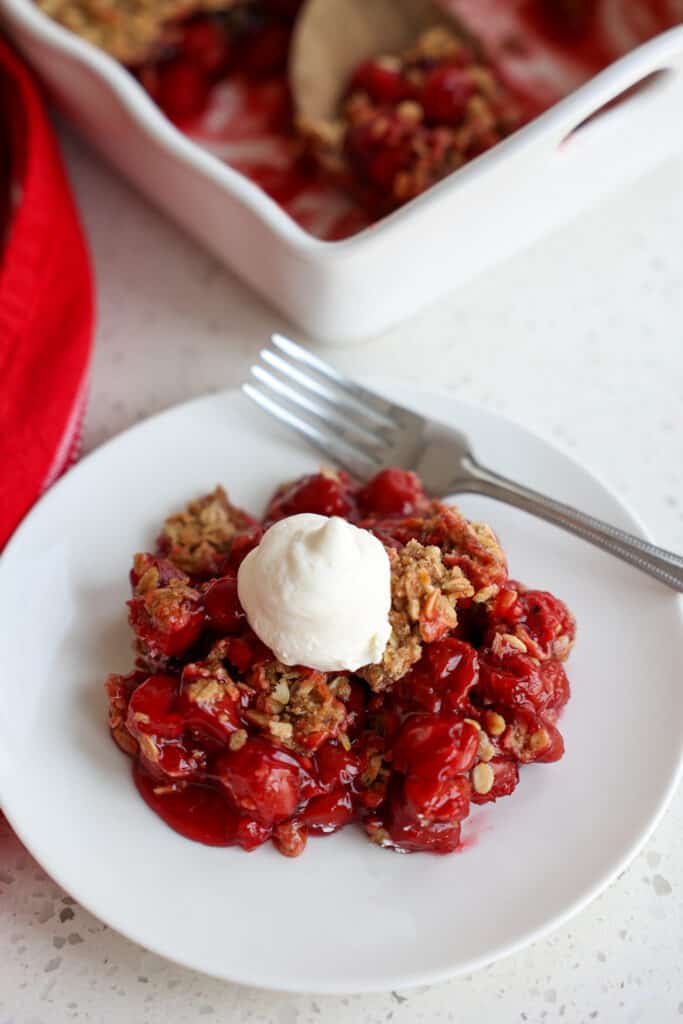 A serving of Cherry Cobbler topped with fresh whipped cream.  