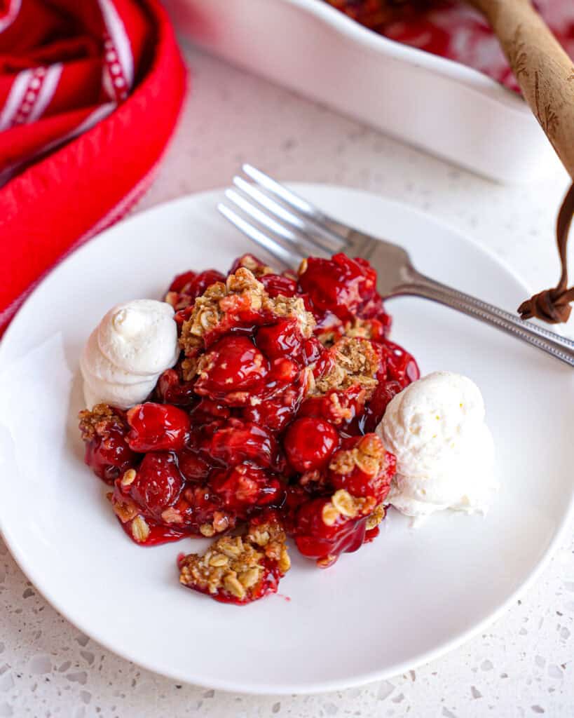 A serving of Cherry Cobbler topped with fresh whipped cream.  