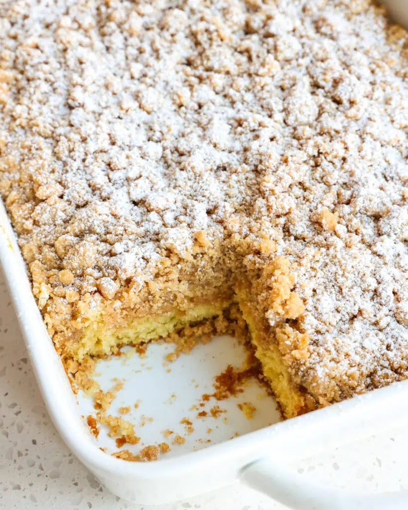 A 9x13 inch baking dish full of crumb with a slice cut out of it. 