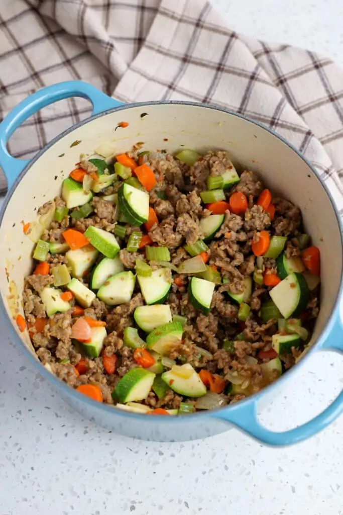 Brown the sausage, onions, celery, carrots, and zucchini. 