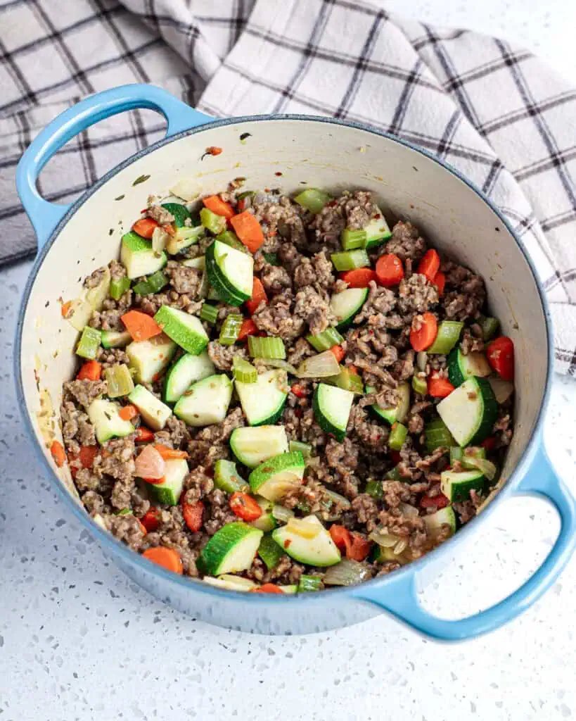 Brown the sausage, onions, celery, carrots, and zucchini.