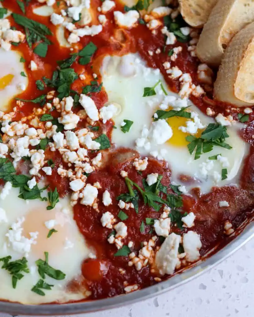 Eggs poached in tomato sauce sprinkled with feta cheese and parsley. 