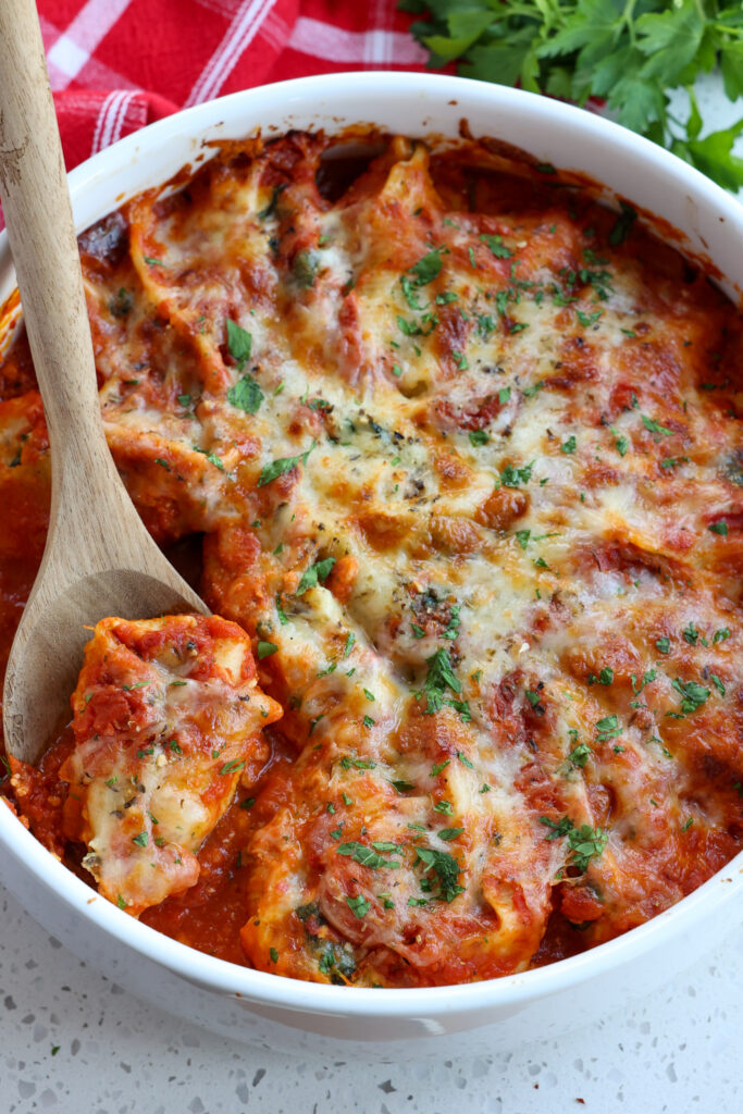 A casserole full of ricotta stuffed shells with spinach and garlic.