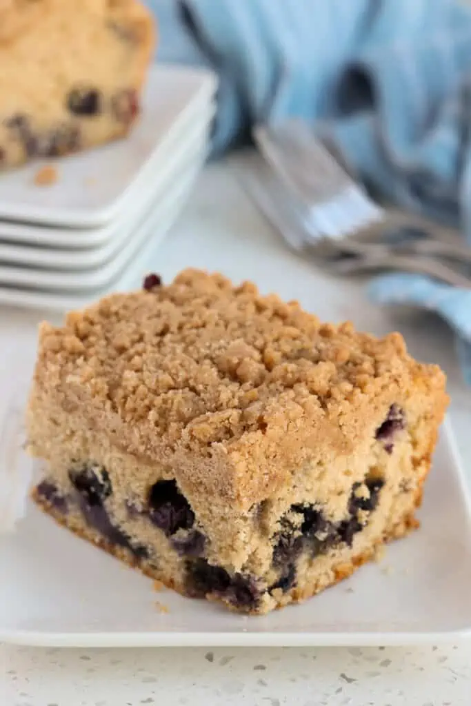 A slice of blueberry buckle on a dessert plate. 