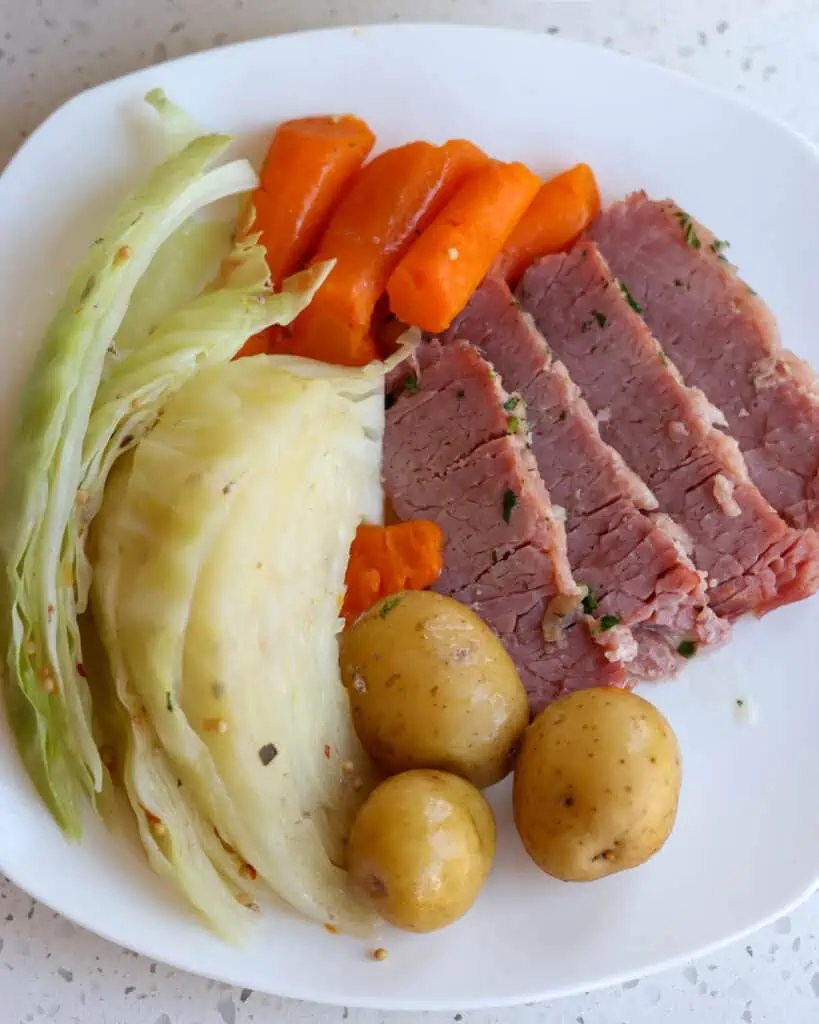 A plate full of corned beef, cabbage, potatoes, and carrots