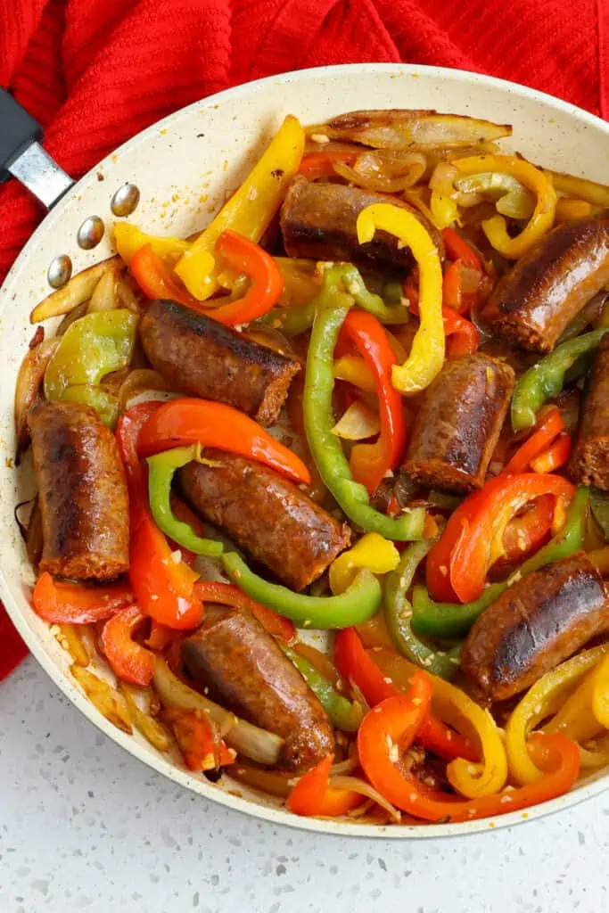 A skillet full of cooked Italian Sausage, peppers, and onions