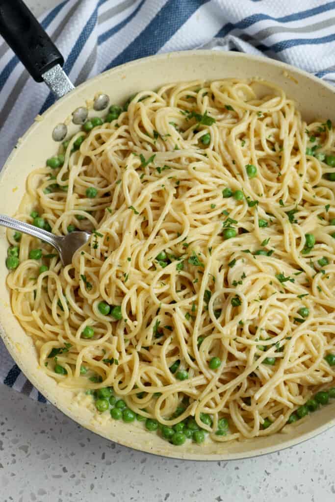 Mix the pasta noodles into the sauce with the peas and fresh chopped parsley. 