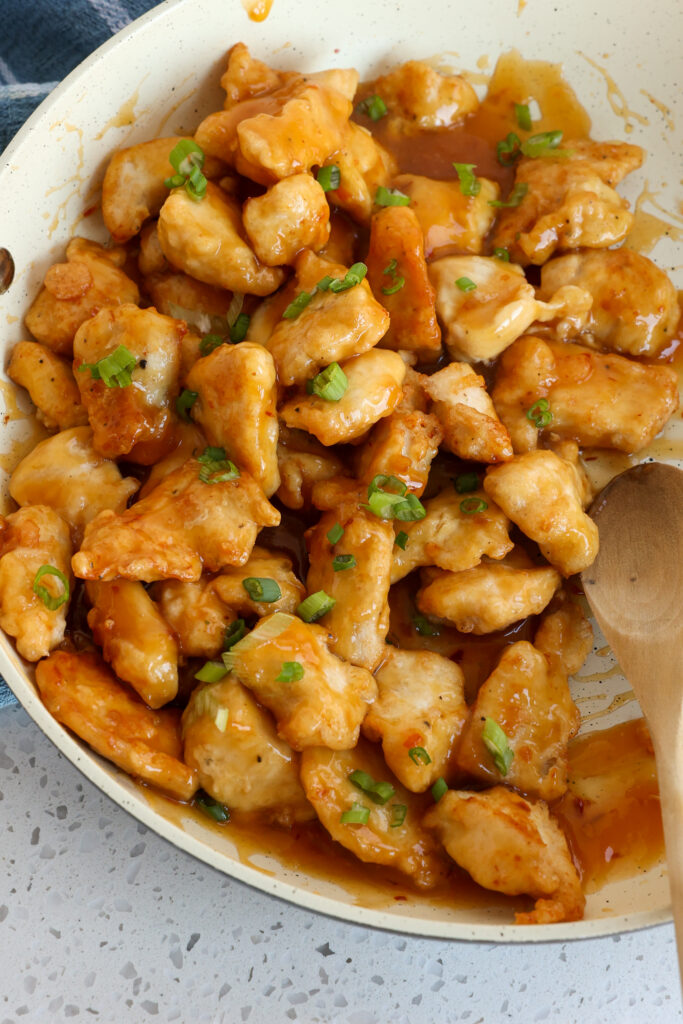 A skillet full of orange chicken