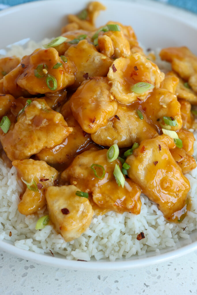 Lightly battered fried chicken pieces in orange sauce. 