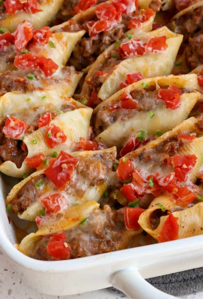 Taco stuffed pasta shells topped with diced tomatoes, green chilies, and minced jalapeno. 