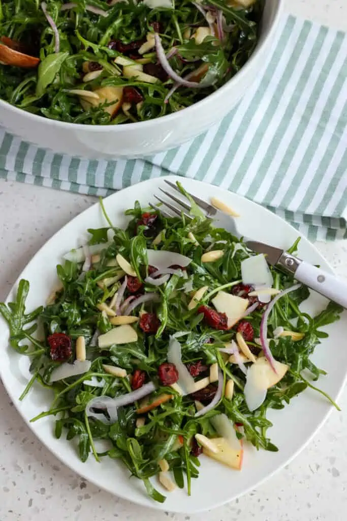 A plate full of Arugula Salad with Lemon Mustard Vinaigrette. 