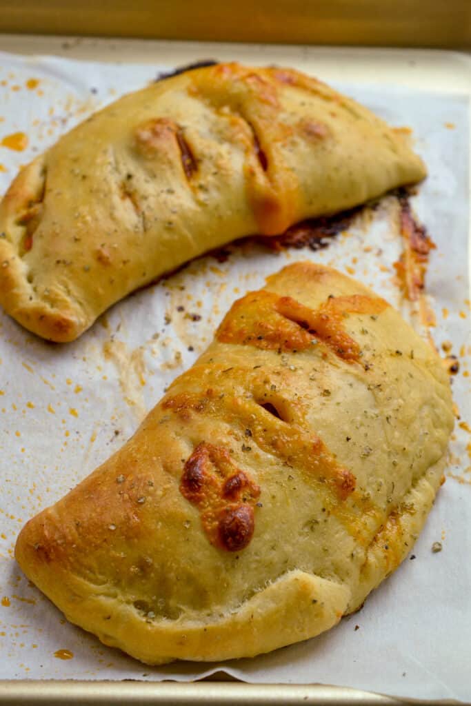 Homemade calzone on a baking sheet.