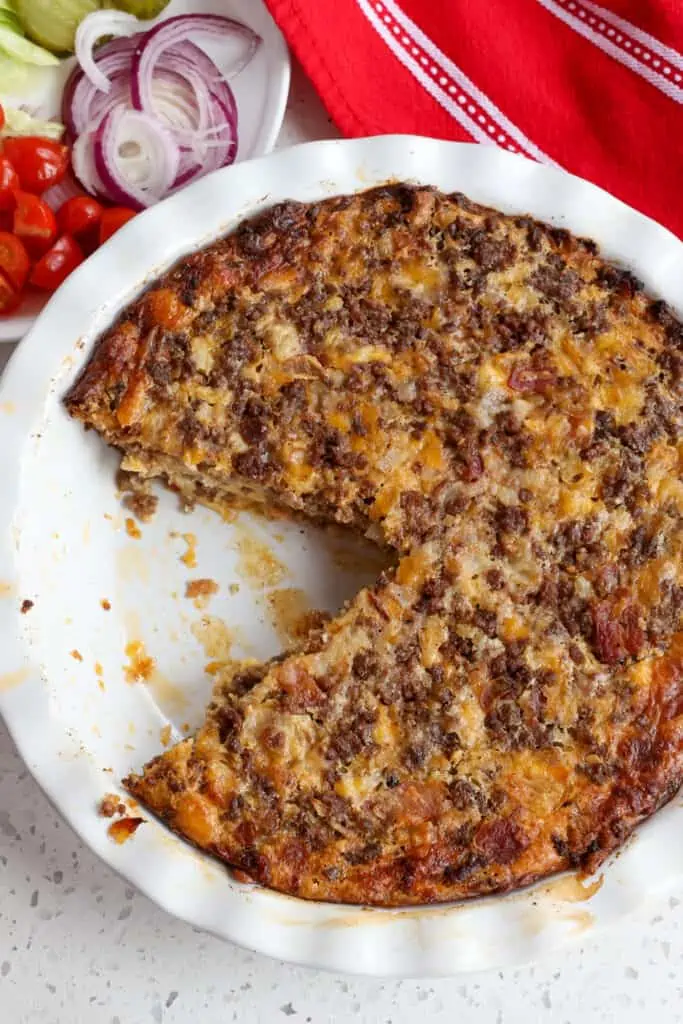A cheeseburger pie with one slice removed.  