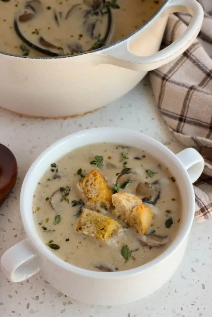 A bowl full of creamy mushroom soup with homemade croutons. 