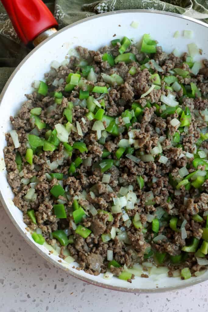 Brown the ground beef and sausage. Then add the onions, celery. and green peppers.