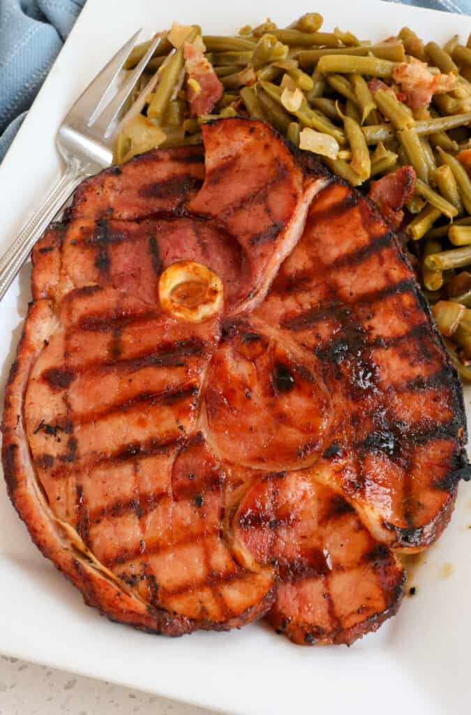 How to Cook Ham Steak Brown sugar glazed ham steak with southern green beans on a platter