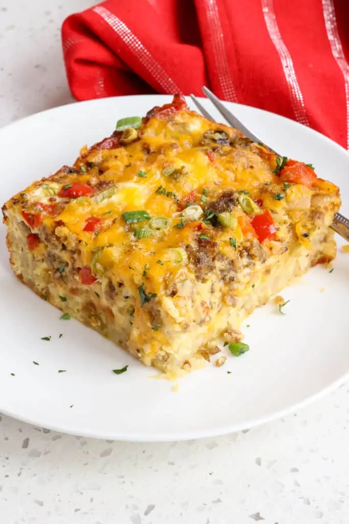 This loaded Hashbrown Breakfast Casserole Recipe is made with frozen hash brown potatoes, pork sausage, sweet onion, red bell pepper, eggs, and plenty of cheddar cheese.