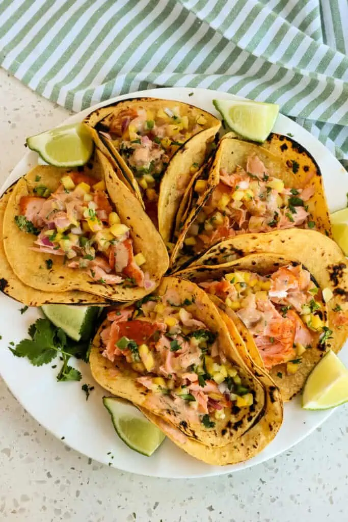 Easy Salmon Tacos made with pan-seared salmon served on corn tortillas with the tastes of mango salsa and chipotle ranch. 