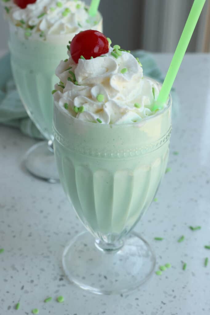 Copycat Shamrock Shakes with whipped cream, maraschino cherries, and sprinkles. 