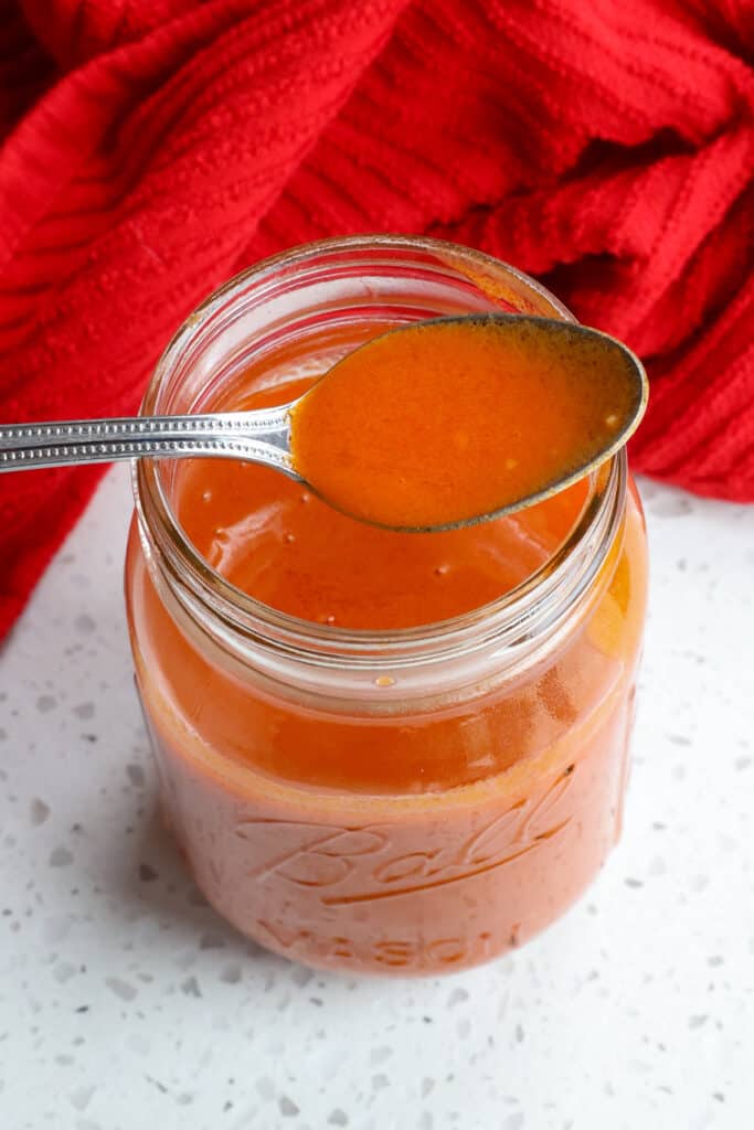 A mason jar full of homemade Buffalo Sauce. 