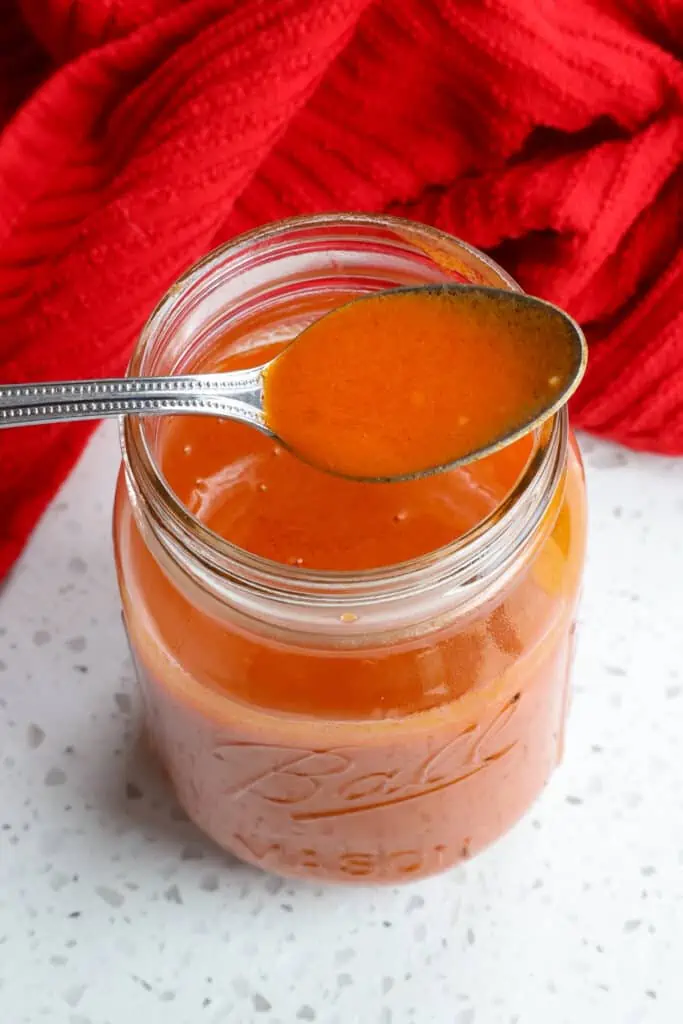 A mason jar full of homemade Buffalo Sauce. 