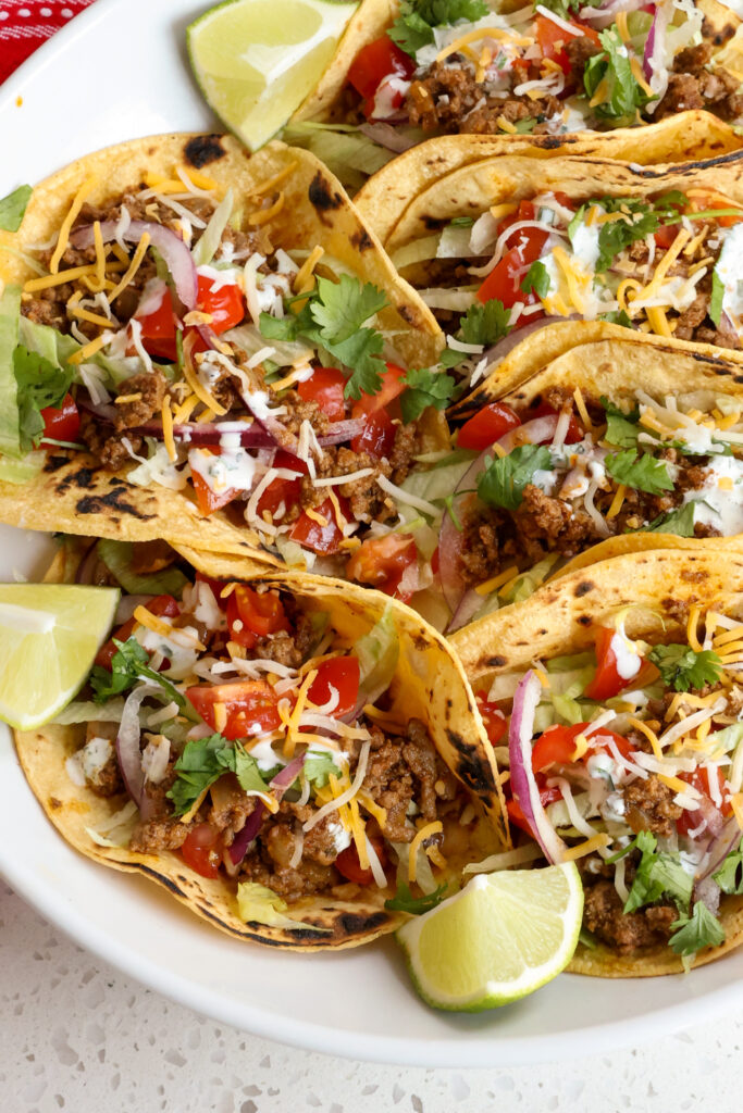 Ground beef tacos with all the fixings in blackened corn tortillas. 