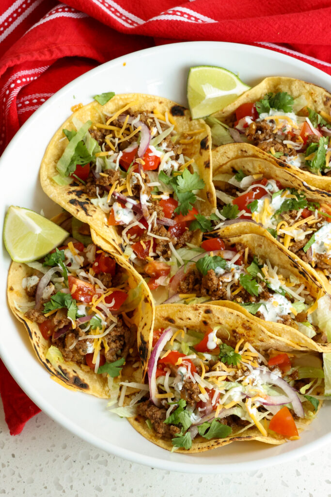 Ground beef tacos with all the toppings, sprinkled with chopped cilantro, and drizzled with chipotle ranch dressing. 