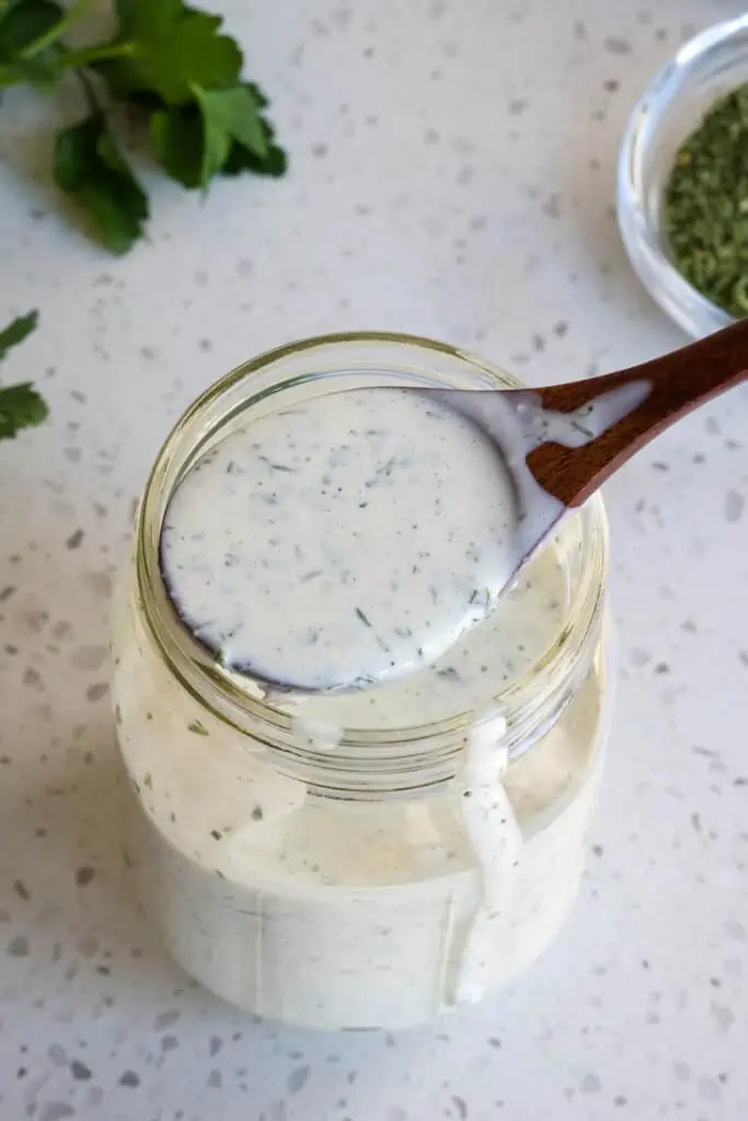 A mason jar full of homemade ranch dressing.  