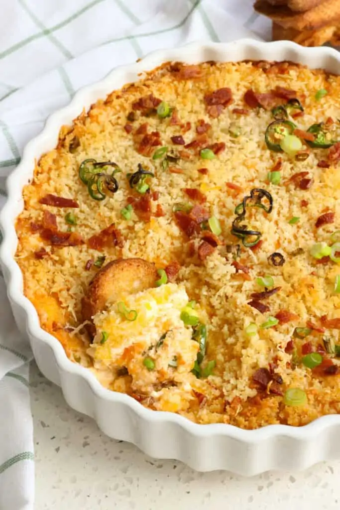 This tasty baked Jalapeño Popper Dip combines green onions, crisp bacon, and fresh jalapeños in a cheddar and cream cheese base, all topped with a buttery parmesan breadcrumb mixture. 