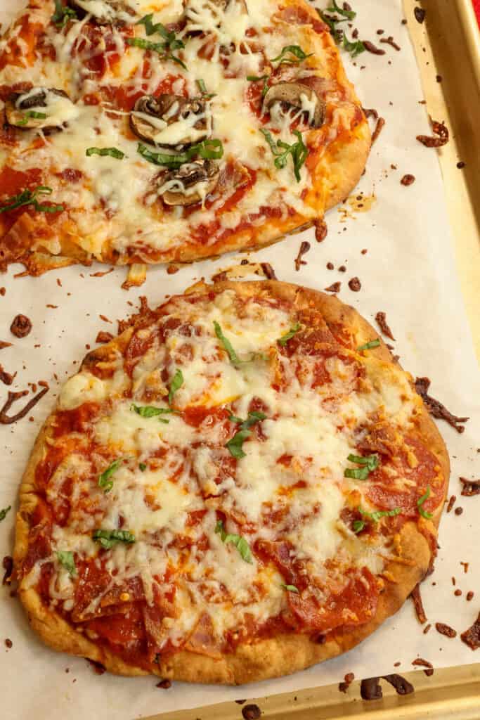 Bake the naan pizza bread on a baking sheet covered with parchment paper.