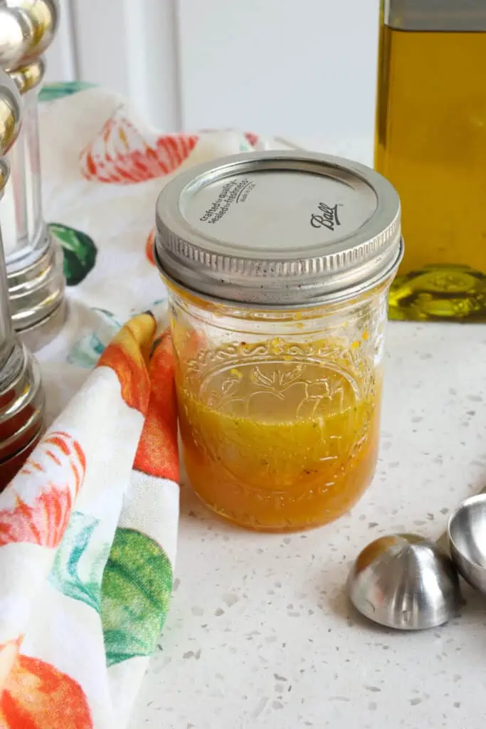 A mason jar full of homemade orange vinaigrette. 