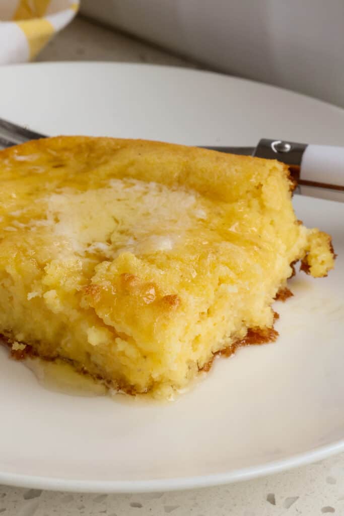 Kentucky spoon bread on a plate with butter. 