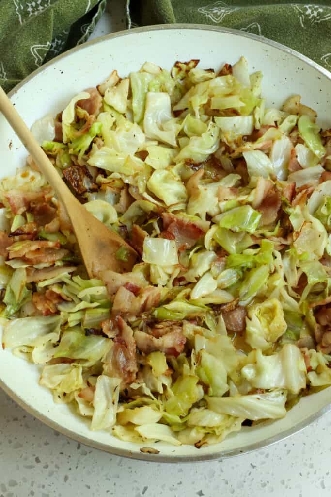 Melt the butter in a large skillet over medium heat. Add the bacon and onion to the skillet until the onions are soft and the bacon is almost completely browned.  