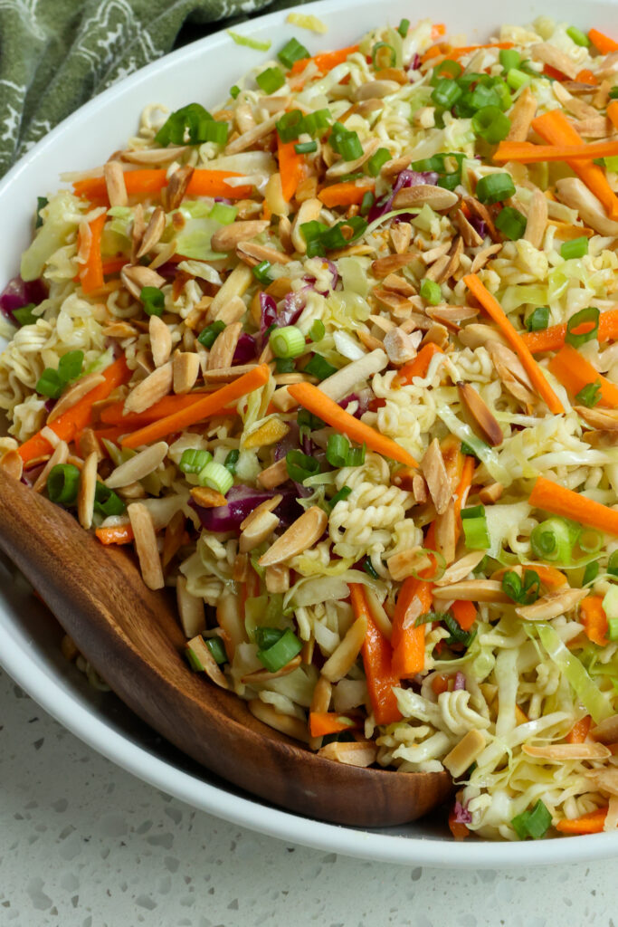 This crunchy Ramen Noodle Salad combines green cabbage, red cabbage, ramen noodles, green onions, carrots, and toasted almonds all tossed in a honey garlic ginger sesame dressing