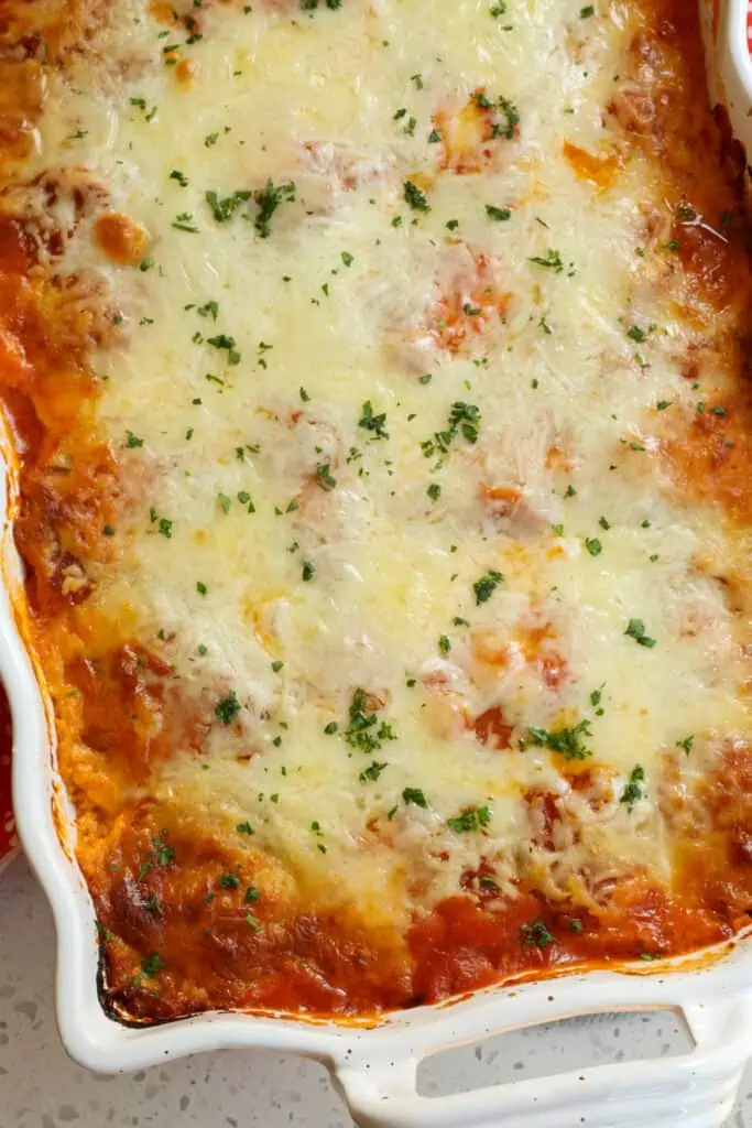 This hearty and easy Ravioli Lasagna Recipe is layers of cheese ravioli, cooked Italian sausage, spinach, onions, ricotta, marinara, and mozzarella. 