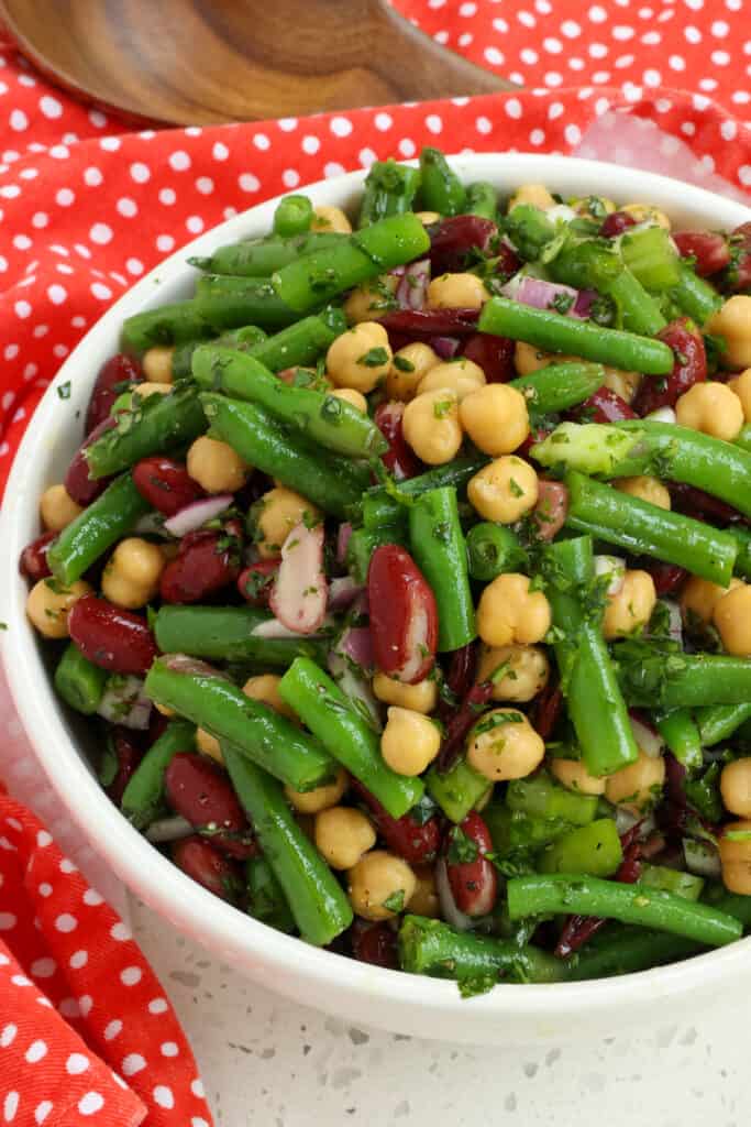 This classic Three Bean Salad brings green beans, garbanzo beans, and kidney beans together in a sweetened oil and vinegar dressing seasoned with fresh parsley and rosemary. 