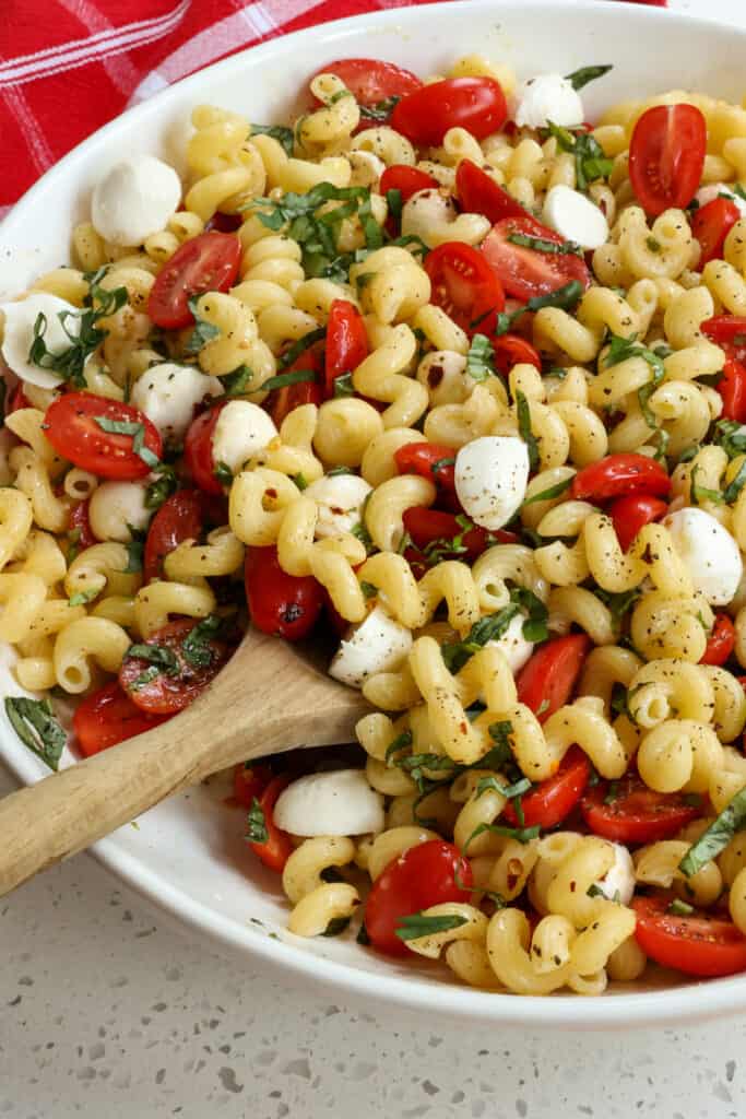 This flavor packed cold Caprese Pasta Salad brings the best that summer produce has to offer with pasta, tomatoes, mozzarella pearls, and fresh basil together in a tasty garlic balsamic vinaigrette.