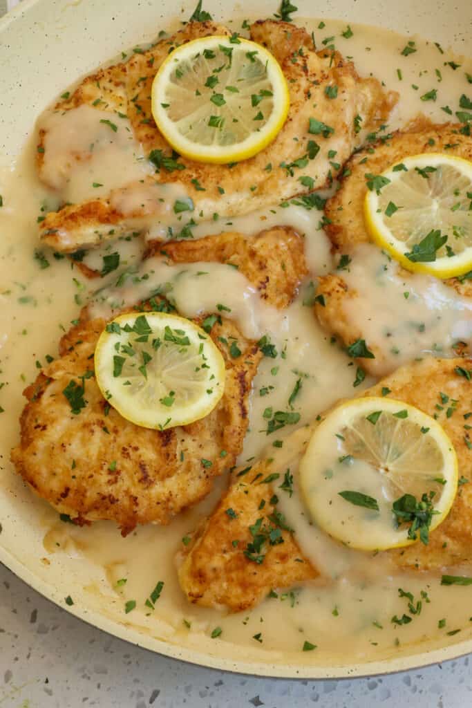 Easy Chicken Frances is chicken breaded in first flour and then eggs pan fried and served in a white wine lemon sauce with fresh lemons and chopped Italian parsley.