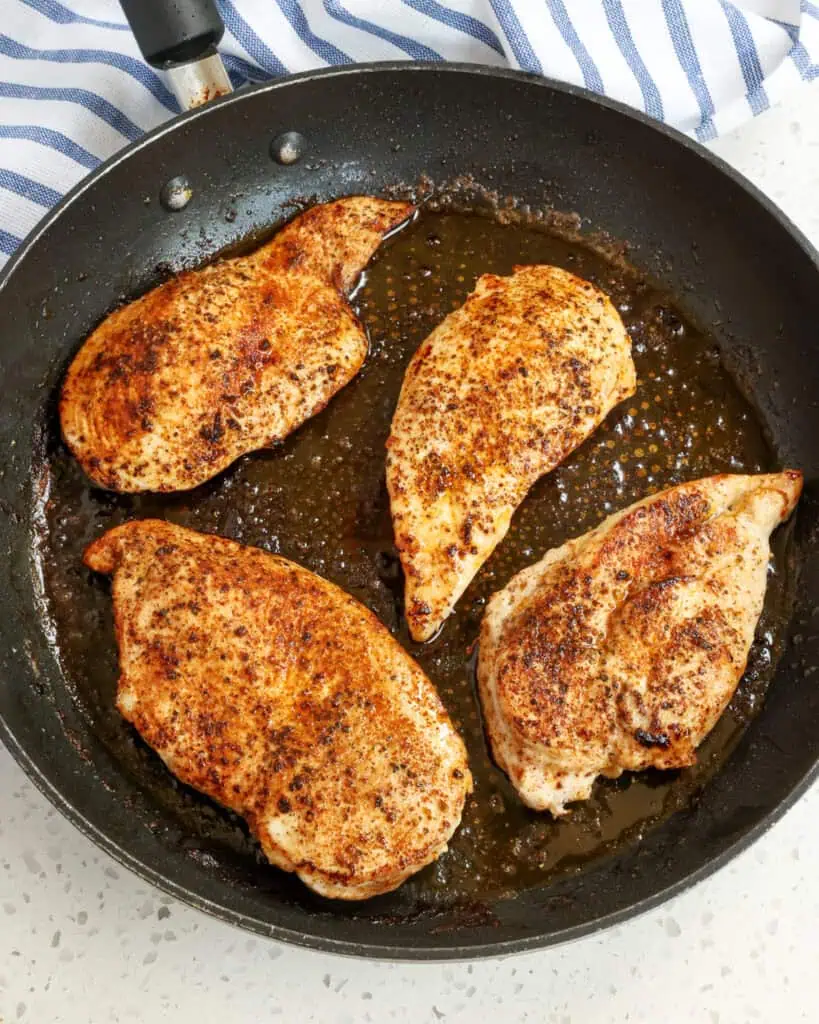 Add a little butter and olive oil to a large skillet over medium heat.  Add the chicken and cook until golden brown on both sides.  